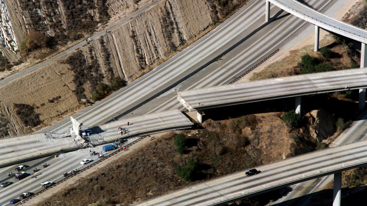 Vista aérea de autos destrozados que cubren la rampa del conector desde la Interestatal 5 a la Carretera 14 luego del terremoto de Northridge, el 17 de enero de 1994, en Northridge, California. Durante el terremoto de Northridge, los daños fueron generalizados, las secciones de las principales autopistas se derrumbaron, las estructuras de estacionamiento y los edificios de oficinas colapsaron, y numerosos edificios de apartamentos sufrieron daños irreparables. (CARLOS SCHIEBECK / AFP / Getty Images)