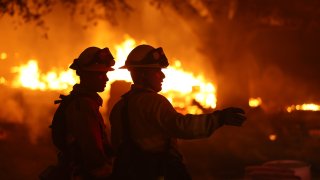 Firefighters battle the Glass Fire on October 01, 2020 in Calistoga, California. The fast moving Glass Incident Fire, originally called the Glass Fire, has burned 56,000 acres in Sonoma and Napa counties and has destroyed numerous wineries and structures. The fire is five percent contained.