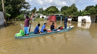 Un grupo de cinco personas rescata sus pertenencias a bordo de una canoa