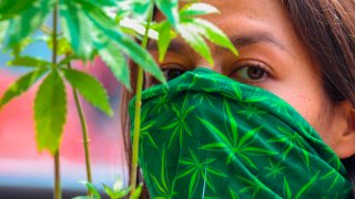 Mujer con cubrebocas con diseño de marihuana