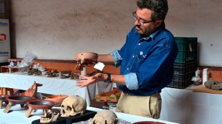 Un arqueólogo revisa restos prehispánicos hallados en Puebla, México.