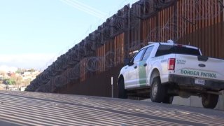 Border Patrol truck in front of the border wall