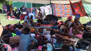 Grupo de migrantes descansa en un campamento