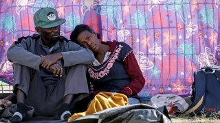 una pareja de migrantes descansa en su marcha hacia la frontera con Estados Unidos