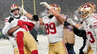 Kicker Robbie Gould #9 of the San Francisco 49ers is congratulated by teammates after kicking the game-winning field goal to win the NFC Divisional Playoff game against the Green Bay Packers at Lambeau Field on January 22, 2022 in Green Bay, Wisconsin.