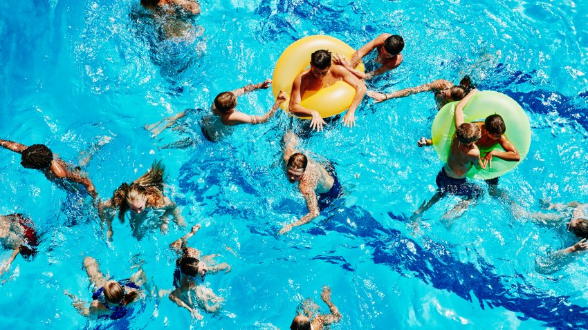 Group of kids playing together in outdoor pool overhead view