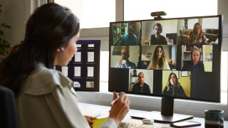 Mujer de negocios discutiendo con colegas durante una videoconferencia.