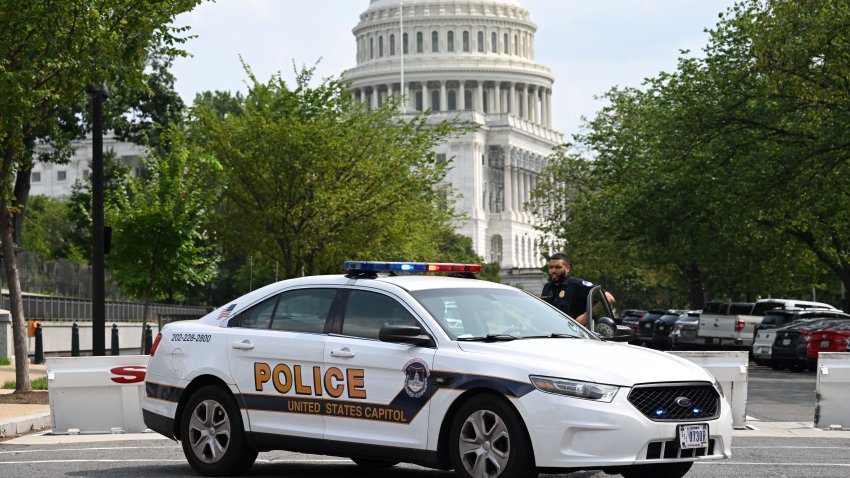 A US Capitol police officer stands by his car outside the Russell Senate Office Building in Washington, DC, on August 2, 2023, after unconfirmed eports of an active shooter in the building near the US Capitol. (Photo by SAUL LOEB / AFP) (Photo by SAUL LOEB/AFP via Getty Images)