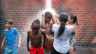 Un grupo de niños juega con el agua en el Millennium Park en Chicago este martes.