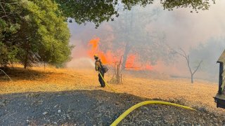 A firefighter battles the Glenhaven Fire in Lake County.