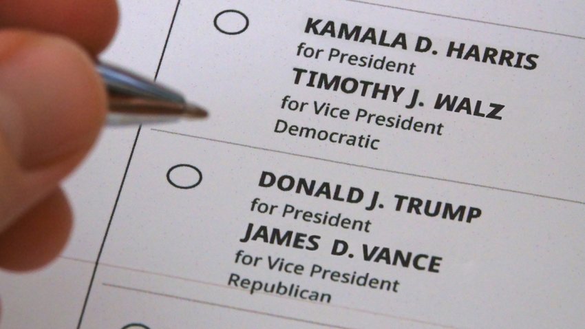 California, USA, Aug. 7, 2024: A hand hovers between voting for Kamala Harris and Tim Walz or Donald Trump and JD Vance on a representation of a printed paper ballot for the presidential election.