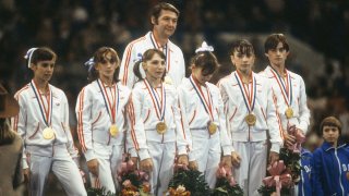 Foto de Archivo: El entrenador del equipo de Rumania, Bela Karolyi, gana con las gimnastas luciendo medallas durante la ceremonia de premiación. Vista de Nadia Comaneci a la extrema derecha. Fort Worth, TX 7/12/1979.