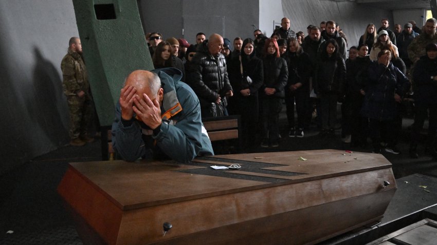 TOPSHOT – Father of late Ukrainian serviceman Daniil Liashkevych reacts on the coffin of his son inside a Baikove crematorium in Kyiv during mourning ceremony on November 8, 2024. Hundreds gathered in the biting cold in Kyiv to mourn military medic Valentyna Nagorna and soldier Daniil Liashkevych, who fell in love during the war and died together. (Photo by Sergei SUPINSKY / AFP) (Photo by SERGEI SUPINSKY/AFP via Getty Images)