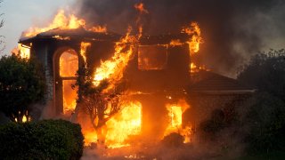 Una casa arde en el incendio Mountain, el miércoles 6 de noviembre de 2024, en Camarillo, California.