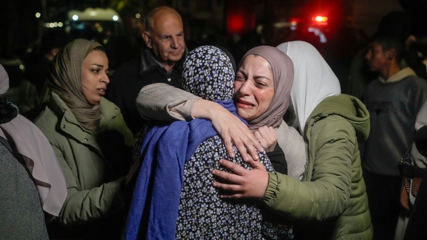 A female Palestinian prisoner, facing the camera, is greeted after disembarking from a bus following her release from an Israeli prison, in the West Bank city of Beitunia, early Monday, Jan. 20, 2025.