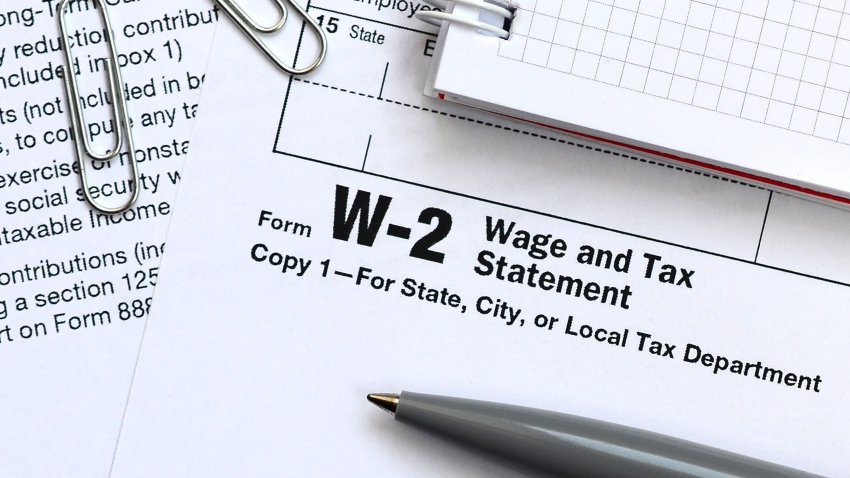 The pen and notebook on the tax form W-2 Wage and Tax Statement. The time to pay taxes