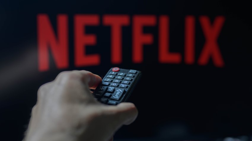 A person is holding a TV remote with Netflix visible in the background in this photo illustration taken in Brussels, Belgium, on May 5, 2024. (Photo by Jonathan Raa/NurPhoto via Getty Images)